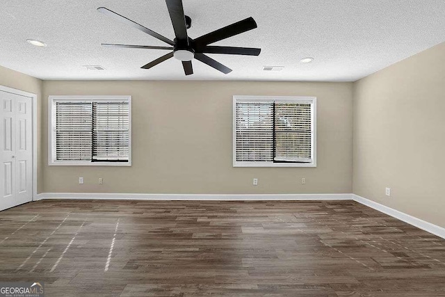 unfurnished room featuring ceiling fan, dark hardwood / wood-style floors, and a textured ceiling