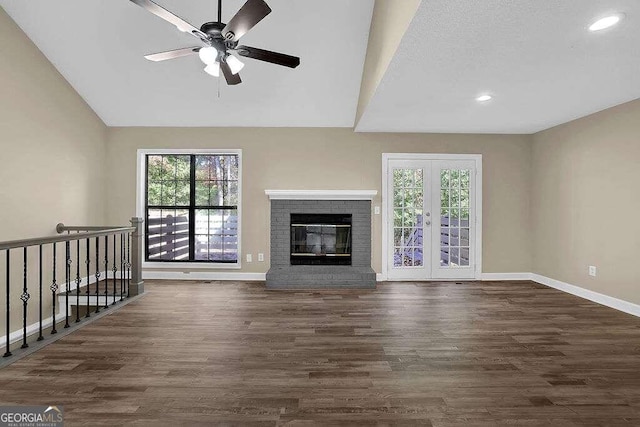 unfurnished living room with ceiling fan, dark hardwood / wood-style flooring, french doors, and a brick fireplace