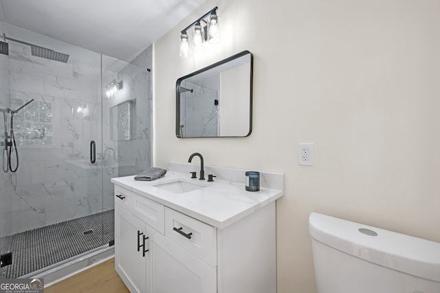 full bathroom with vanity, wood finished floors, a marble finish shower, and toilet