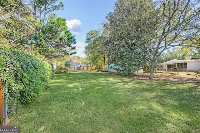 view of yard featuring fence and an outbuilding