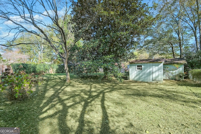 view of yard featuring a fenced backyard, a storage unit, and an outdoor structure