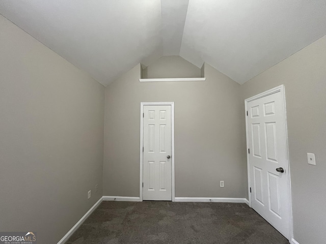 bonus room with lofted ceiling and dark carpet