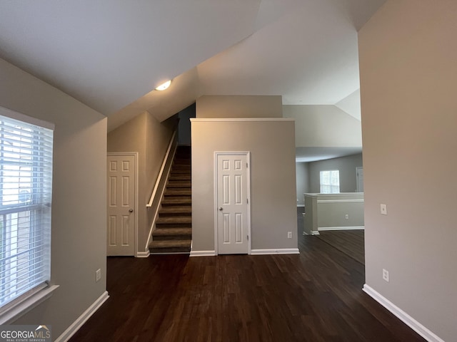 interior space with dark wood-type flooring and vaulted ceiling