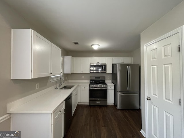 kitchen with stainless steel appliances, dark hardwood / wood-style floors, white cabinets, and sink