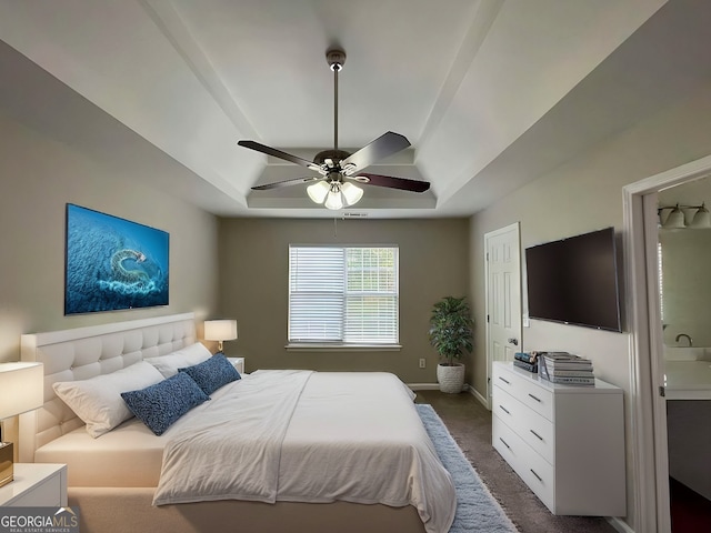 carpeted bedroom featuring a raised ceiling and ceiling fan