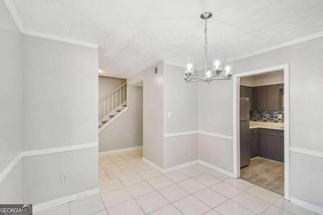 unfurnished dining area with an inviting chandelier, light tile patterned flooring, and ornamental molding