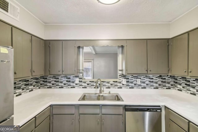 kitchen with decorative backsplash, sink, stainless steel appliances, and a textured ceiling