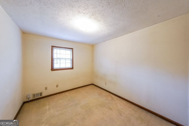 carpeted spare room featuring a textured ceiling