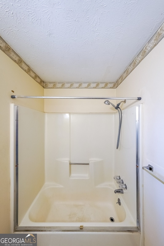 bathroom featuring bathing tub / shower combination and a textured ceiling