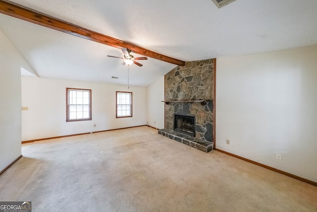 unfurnished living room with lofted ceiling with beams, ceiling fan, light carpet, and a stone fireplace