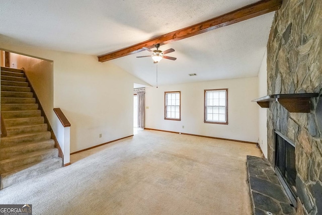 unfurnished living room with vaulted ceiling with beams, light carpet, a fireplace, and a textured ceiling