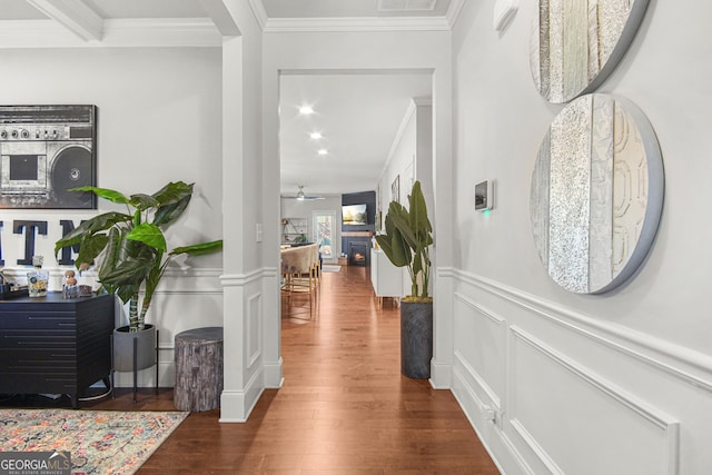 corridor with dark hardwood / wood-style floors, ornamental molding, and decorative columns