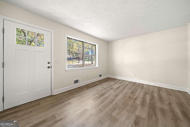 entrance foyer with a textured ceiling and wood-type flooring