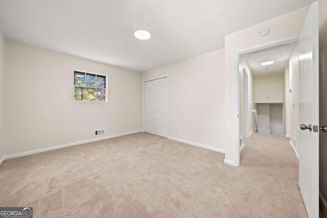 unfurnished bedroom featuring light colored carpet and a closet