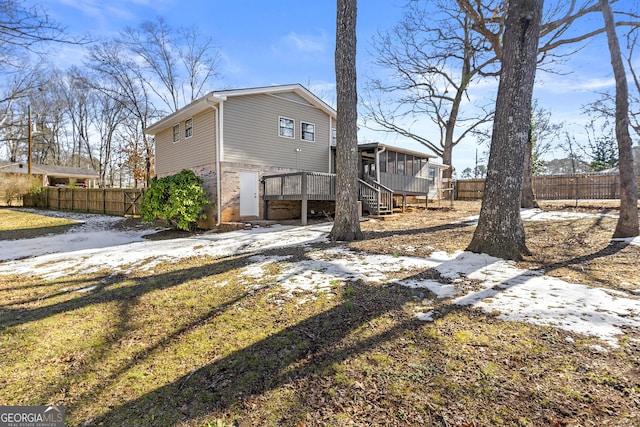 rear view of house featuring a wooden deck and a sunroom