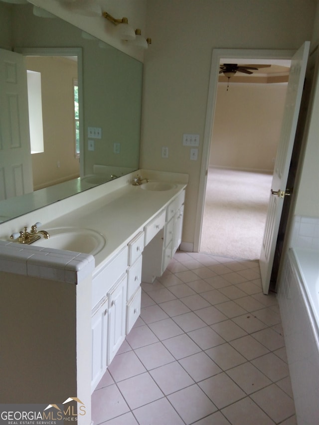 bathroom featuring tile patterned floors, vanity, ceiling fan, and a tub to relax in