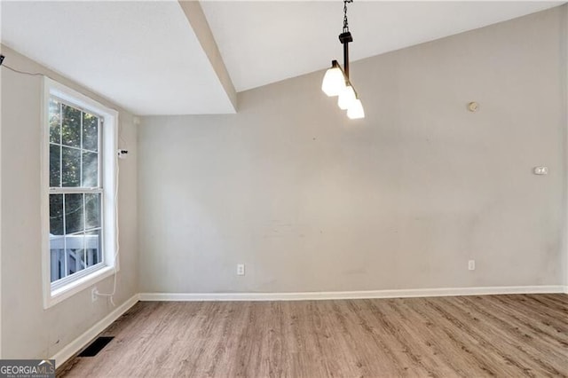 unfurnished dining area featuring wood-type flooring and vaulted ceiling