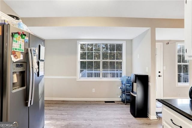 kitchen featuring light hardwood / wood-style floors, white cabinetry, and stainless steel refrigerator with ice dispenser