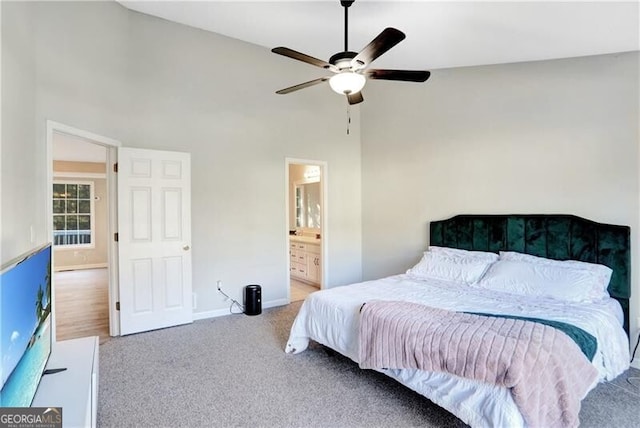 bedroom with carpet flooring, a high ceiling, ensuite bathroom, and ceiling fan