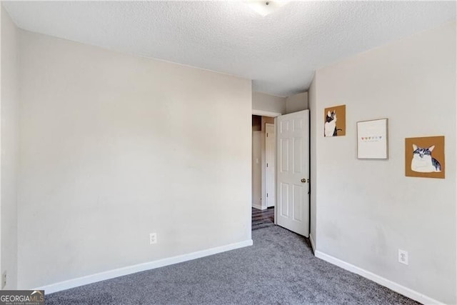 carpeted spare room featuring a textured ceiling