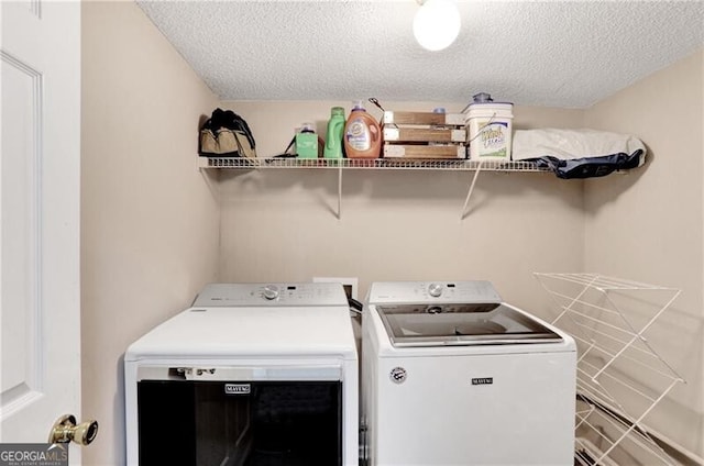 washroom featuring washing machine and clothes dryer and a textured ceiling