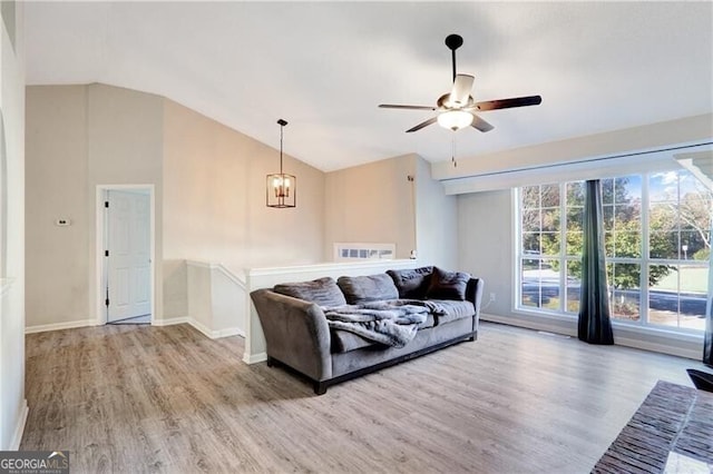 living room featuring a wealth of natural light, lofted ceiling, and light wood-type flooring