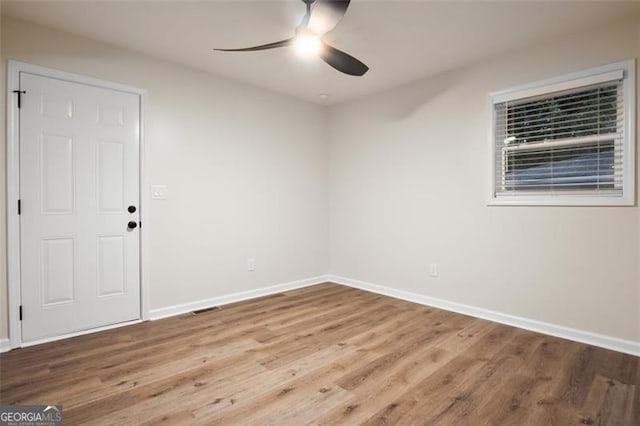 spare room featuring wood-type flooring and ceiling fan