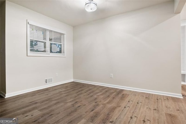 unfurnished room with wood-type flooring