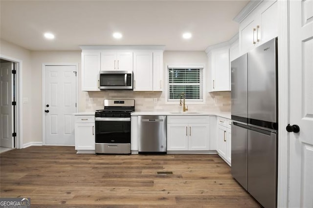 kitchen featuring dark hardwood / wood-style flooring, sink, white cabinets, and appliances with stainless steel finishes