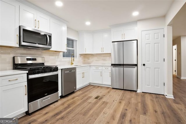 kitchen with white cabinetry, light hardwood / wood-style flooring, and stainless steel appliances