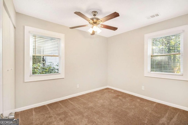 carpeted empty room featuring ceiling fan