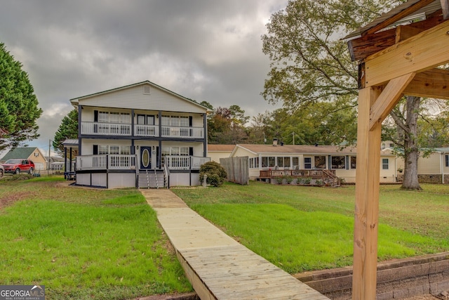 view of front of home with a balcony and a front yard