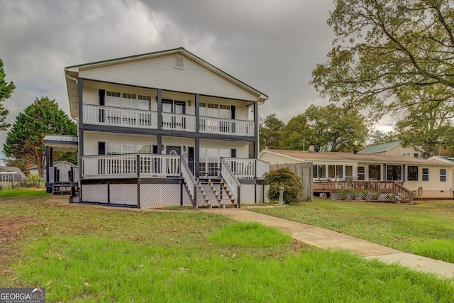 back of property featuring a balcony and a yard