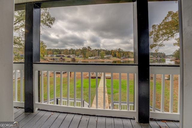 wooden terrace featuring a yard and a water view