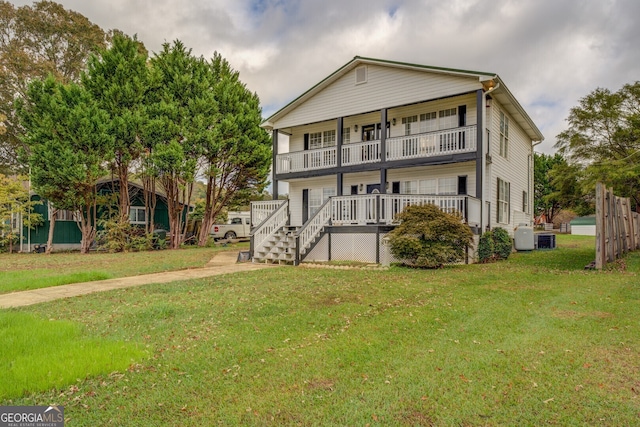 back of house with a yard, a balcony, and a porch