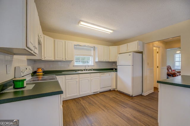 kitchen featuring white cabinets, white appliances, light hardwood / wood-style flooring, and sink