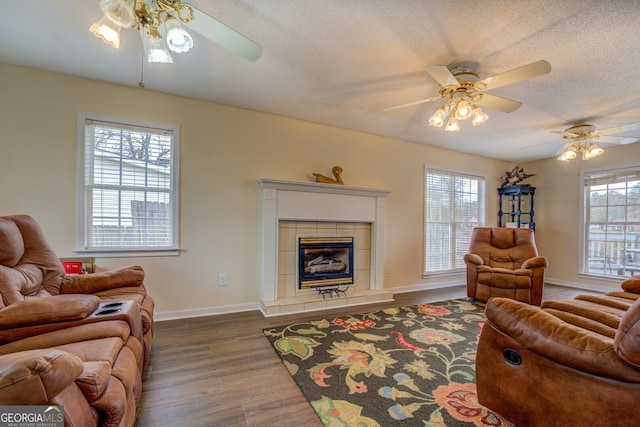 living room featuring ceiling fan, plenty of natural light, and dark wood-type flooring