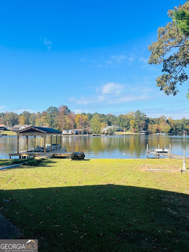 dock area with a yard and a water view