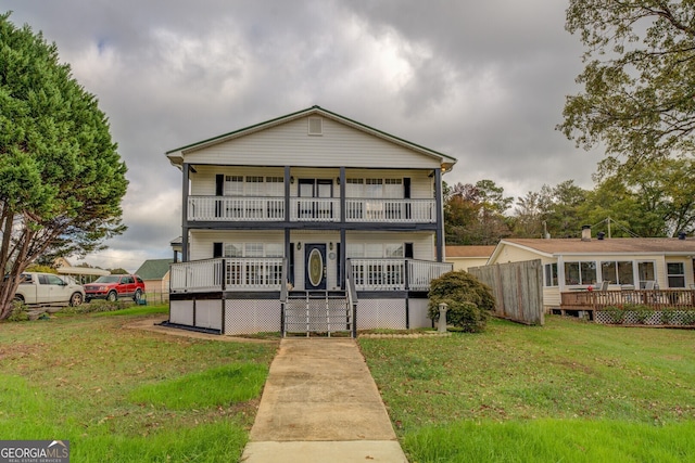 view of front of home with a balcony and a front yard