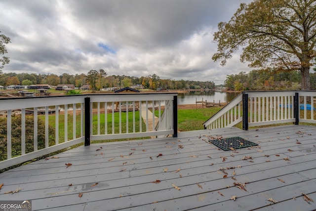 deck with a yard and a water view