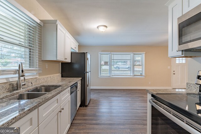 kitchen featuring light stone countertops, dark hardwood / wood-style flooring, stainless steel appliances, sink, and white cabinetry