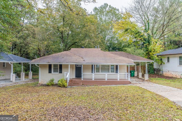 ranch-style home featuring a carport, a porch, and a front yard