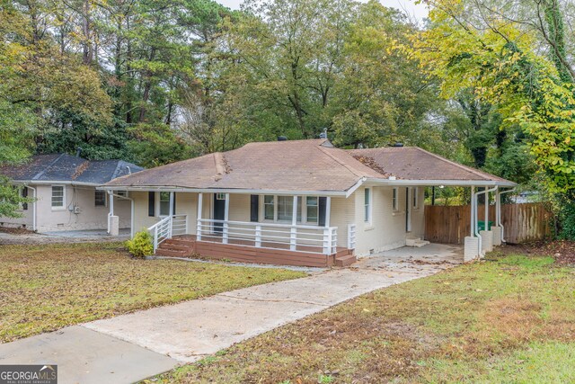 single story home featuring covered porch, a carport, and a front yard