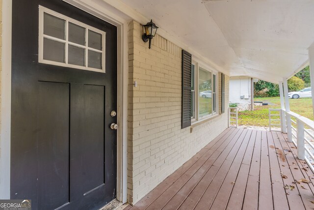 view of exterior entry featuring covered porch