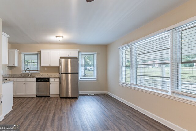 kitchen featuring white cabinetry, stainless steel appliances, a wealth of natural light, and dark wood-type flooring