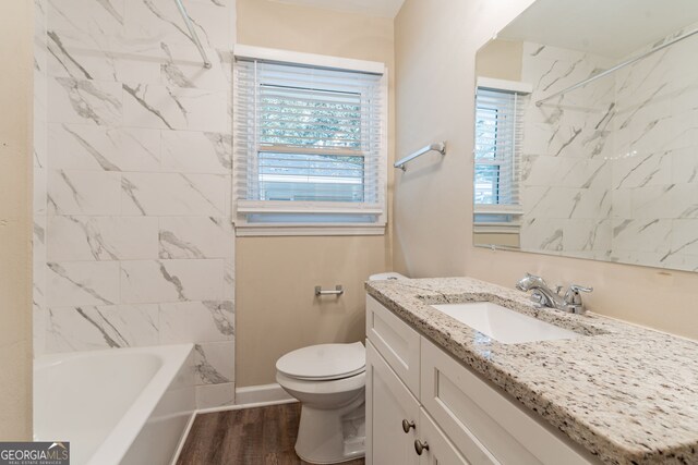 full bathroom with wood-type flooring, vanity, toilet, and tiled shower / bath