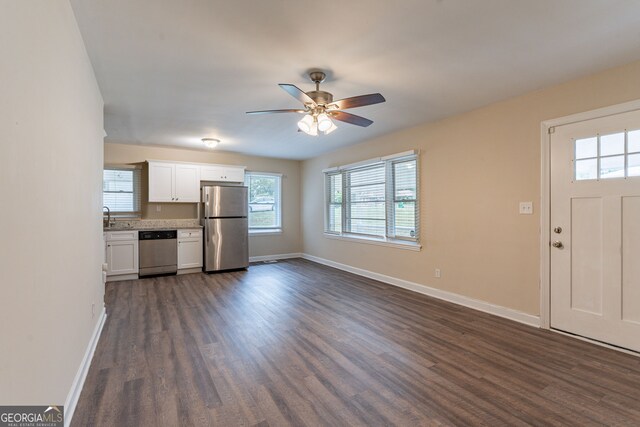 kitchen featuring stainless steel appliances, ceiling fan, dark wood-type flooring, sink, and white cabinetry