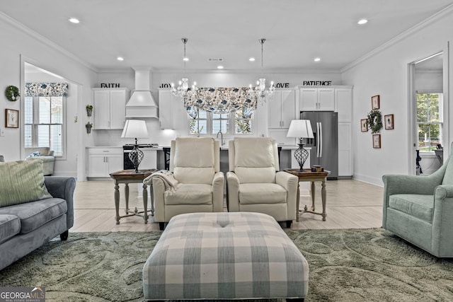 living room with crown molding, an inviting chandelier, and sink