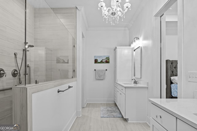 bathroom with a shower with door, vanity, and crown molding