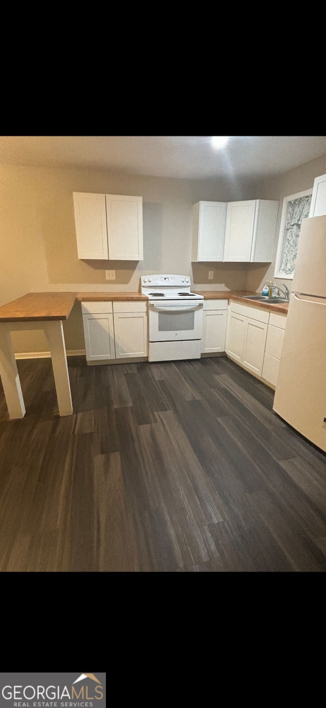 kitchen featuring white cabinetry, sink, white appliances, and dark wood-type flooring